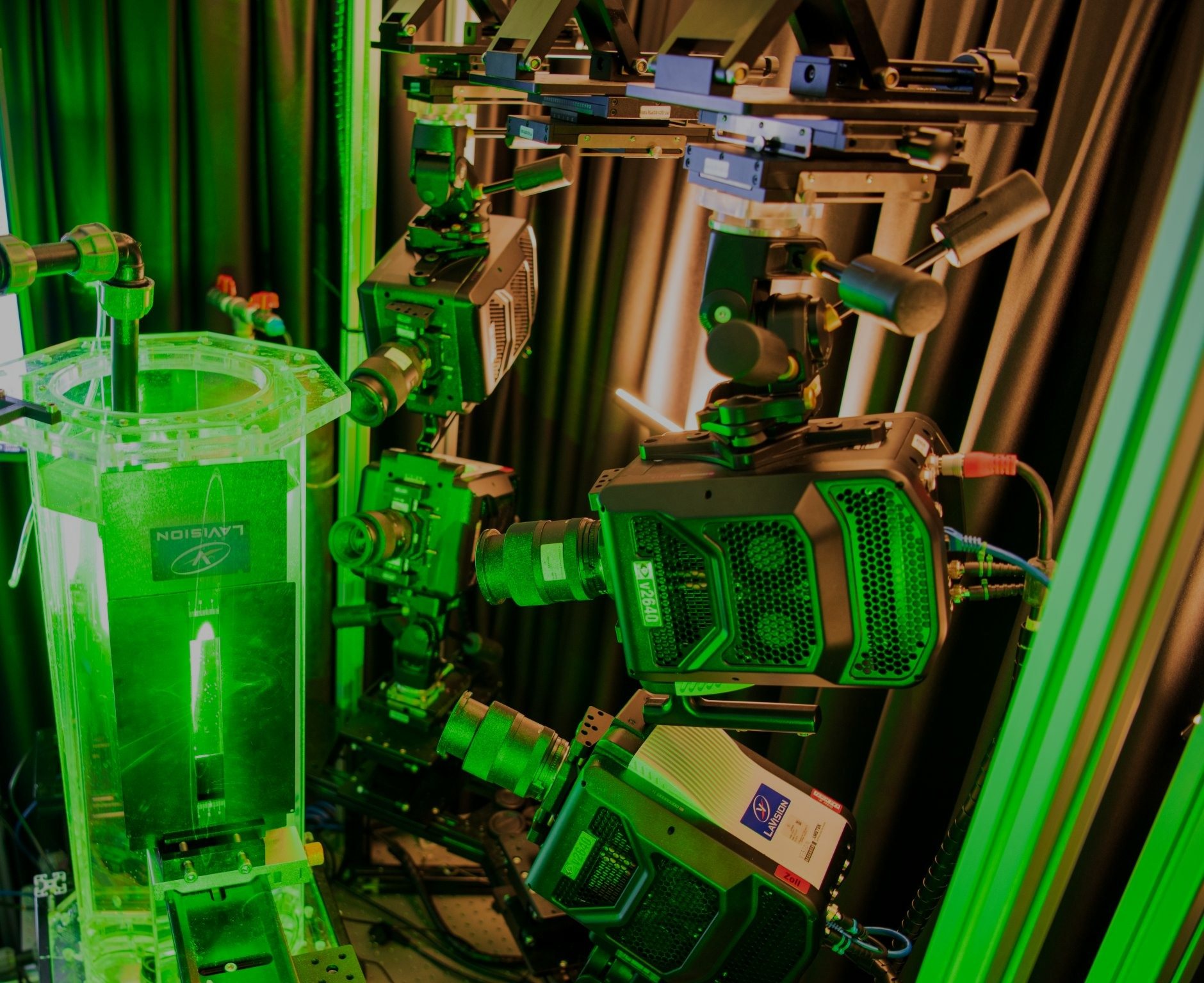 Green laser light illuminates an octagonal tank surrounded by high-speed cameras in the TFML laboratory